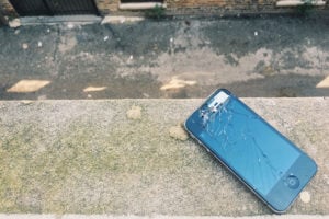 Cracked iPhone on pavement